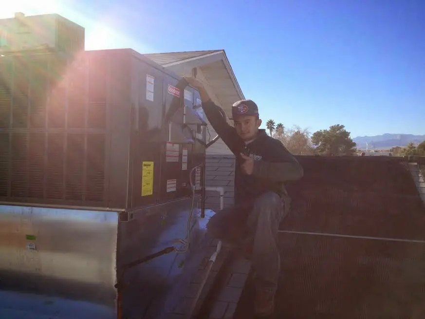HVAC technician performing AC Tune-Up on a rooftop unit in Sunrise